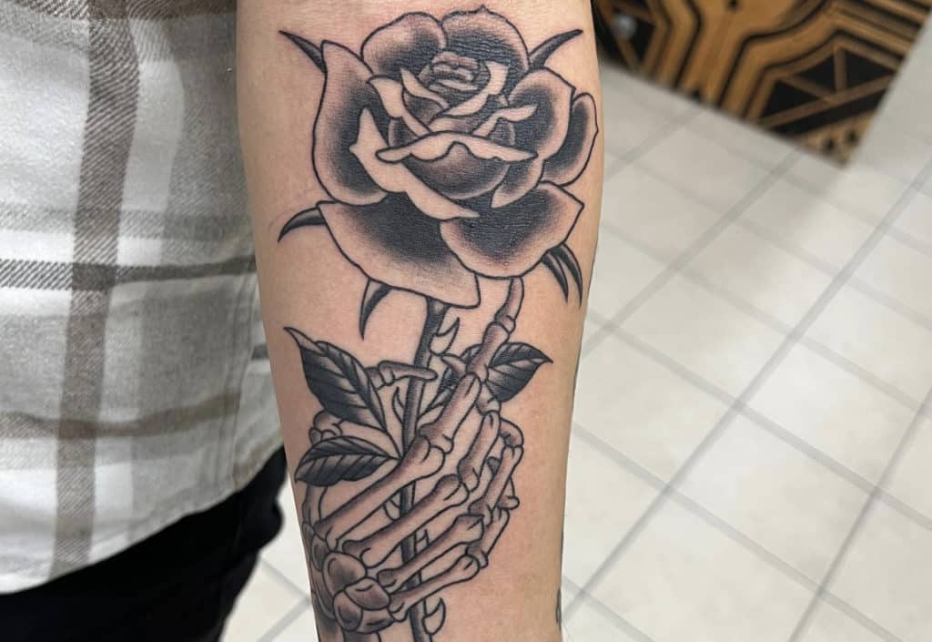 black flower with a skeleton hand on a an art at the tattoo shop in chicago deluxe tattoo