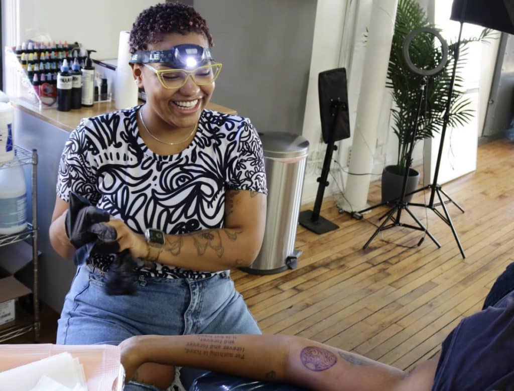syd tattooing someone's arm at her studio in humboldt park