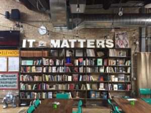 Back room of the cafe and book shop features a wall of bookshelves and a sign that says 'it matters'