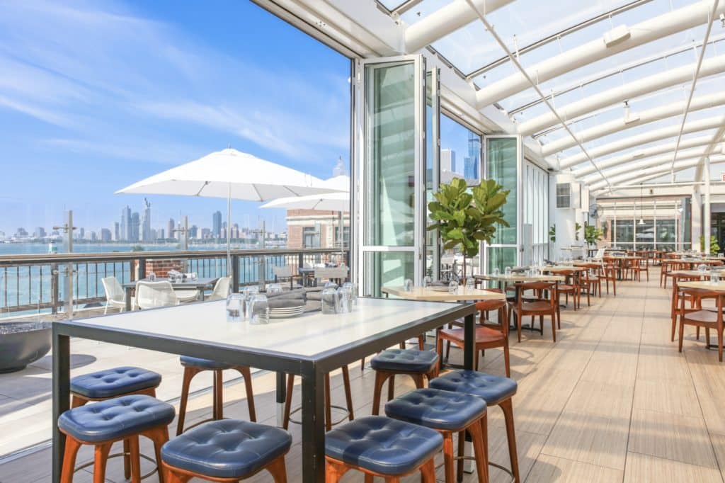 offshore rooftop with tables and tools and a glass rooftop. Views of lake michigan and chicago skyline.