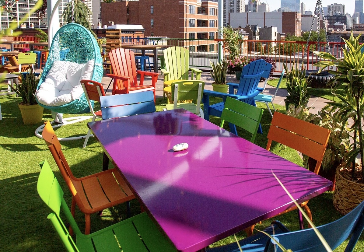 utopian tailgate rooftop bar with vibrant colorful seating and a blue lounge chair all on grass