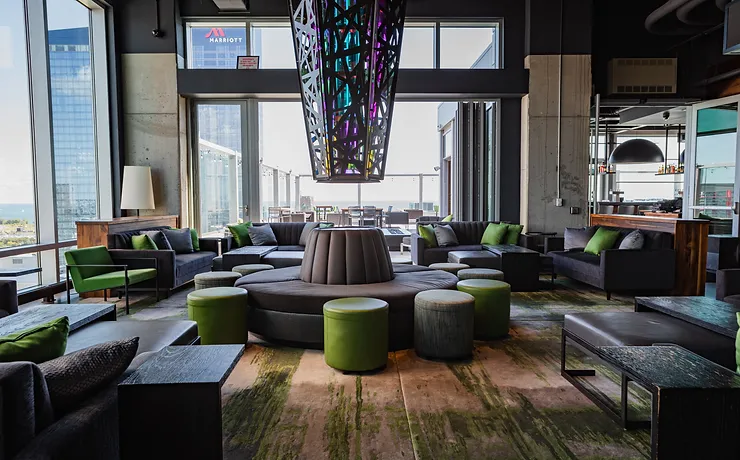 Vu rooftop chicago with gray couches and green ottomans multi-colored light in the center