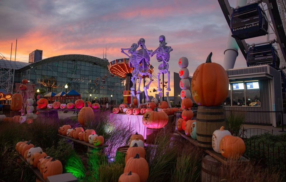 navy pier during halloween with pumpkins and skeletons and lights on the rides 