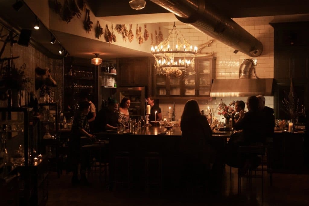 Inside the secret restaurant shows customers at a bar and tables