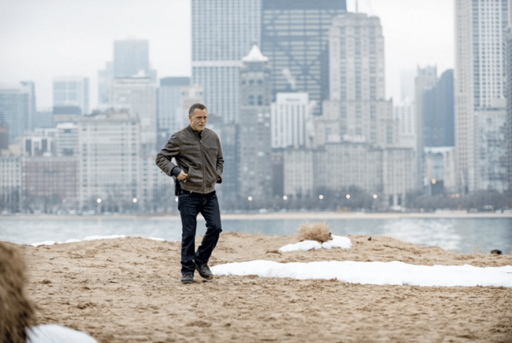 Chicago PD character walking against Chicago skyline backdrop