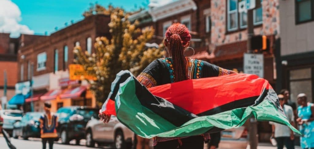 Image showing a person holding a Juneteenth flag in a street