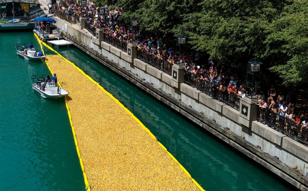 people lined up along the Chicago Riverwalk watching Chicago's annual summer Ducky Derby event