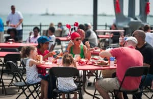 Image showing a family at a table on Navy Pier with food and drinks from the Great American Lobster Fest in Chicago