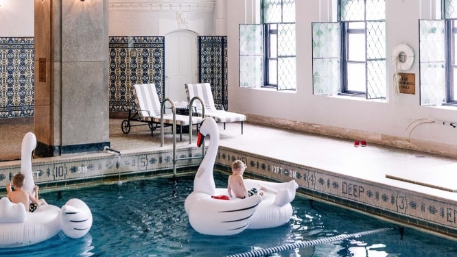 Indoor pool at the hotel with kid on a swan float