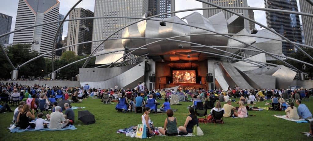 People sitting at the Jay Pritzker Pavilion in Millennium Park