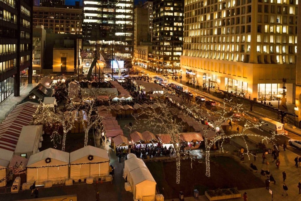 Vendor tents and Christmas lights shown in a plaza