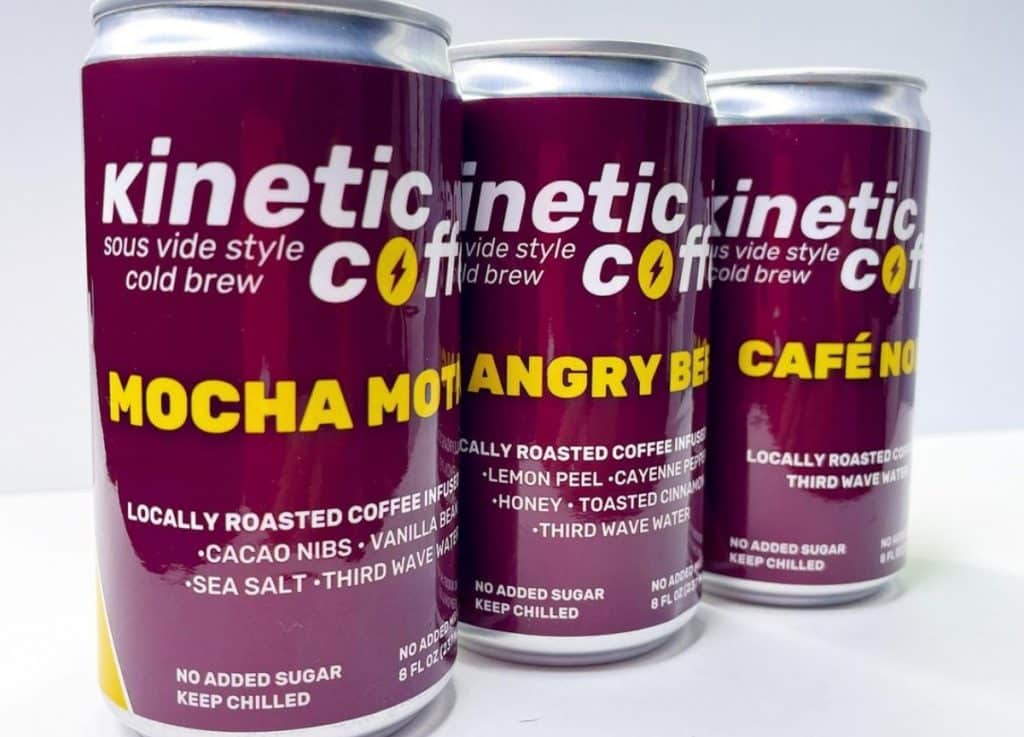 Three cold brew cans seen withKinetic coffee logo