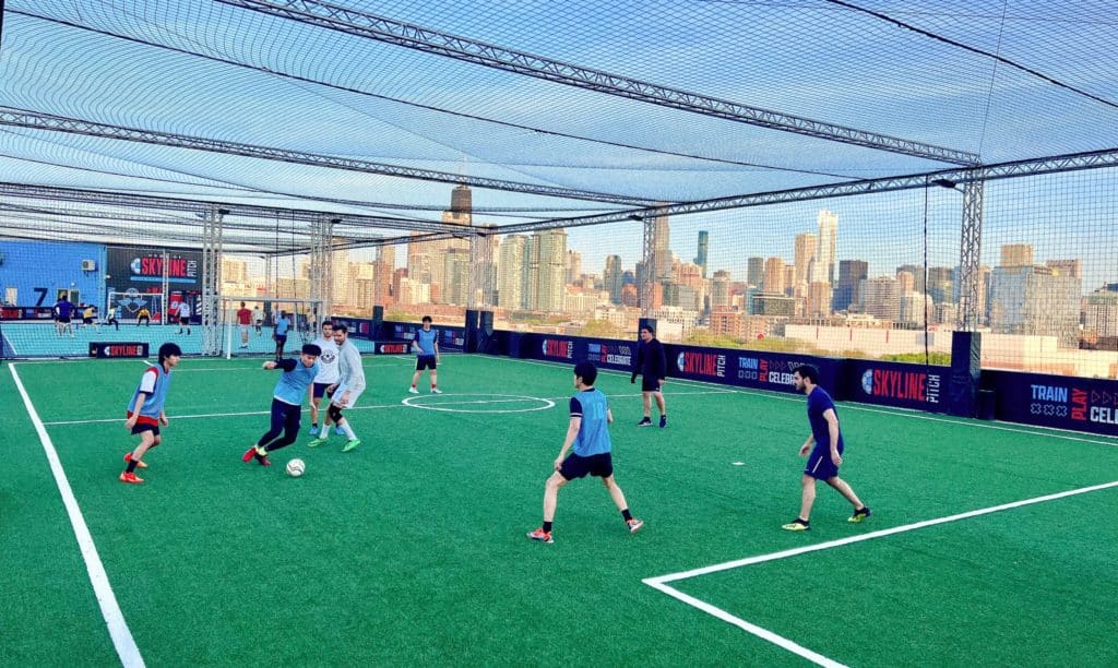kids playing at rooftop soccer with the Chicago skyline in the back