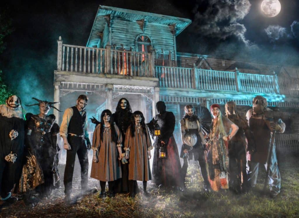 Haunted house seen with terrifying characters standing in front