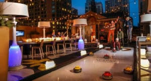 People playing curling by a fire on a luxury Chicago rooftop