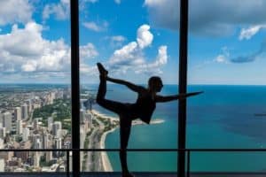 One person practicing yoga with a skyline of Chicago in the background
