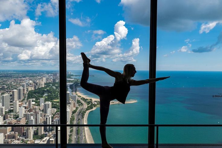 Yoga class participant posing in front of the Chicago skyline seen through the window
