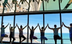 People practicing yoga with a skyline of Chicago in the background