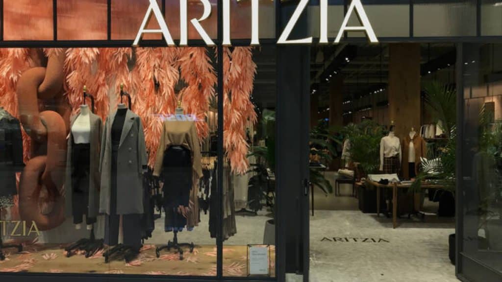 Exterior of an Aritzia storefront shows mannequins dressed up