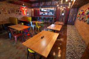Interior design of Dr. Birds shows wooden tables, colorful chairs and ambient lighting
