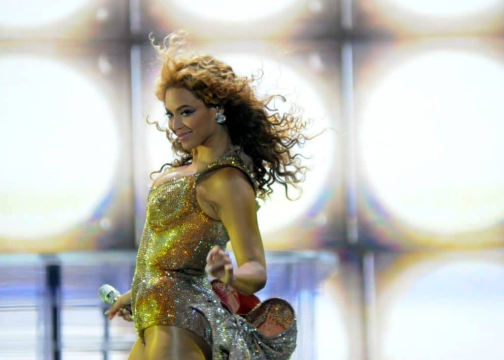 Beyonce performing on stage in a gold outfit