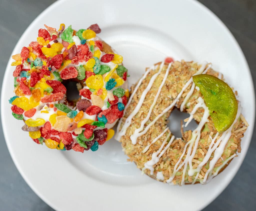 fruit loops donut next to a white drizzled donut with a lime at fremont