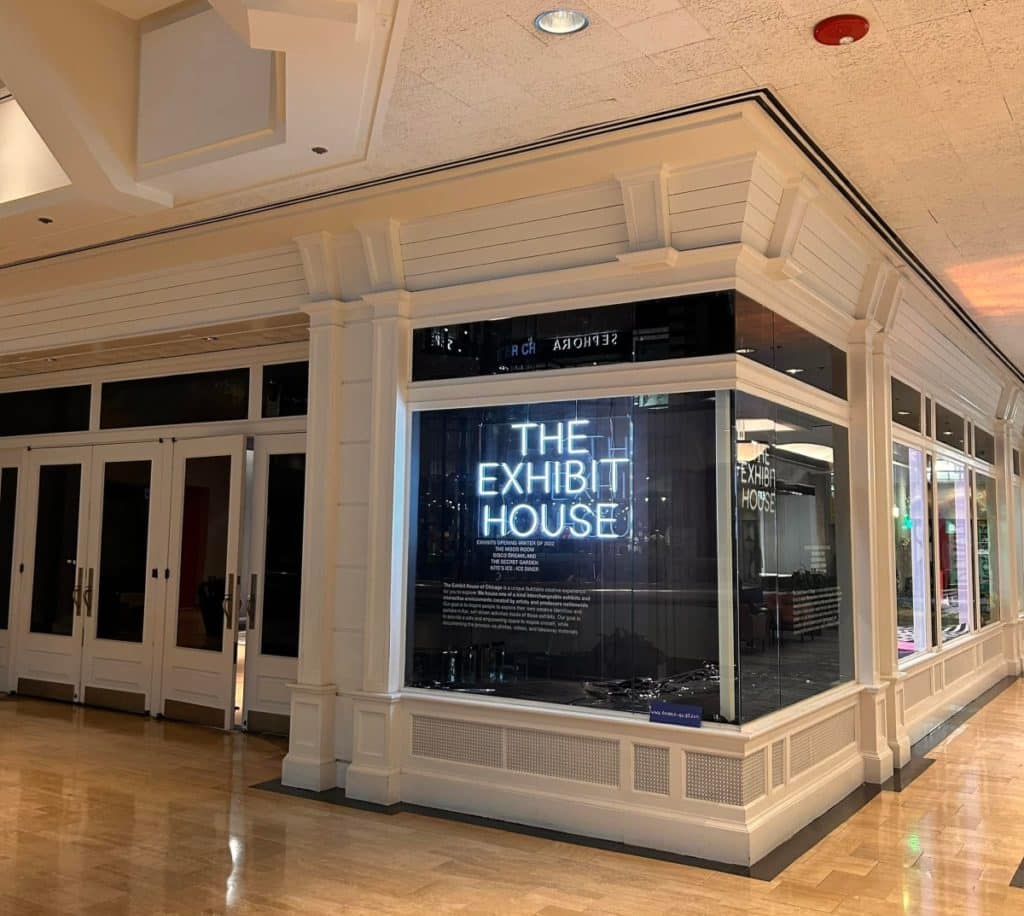 Exterior of the museum shows a standard storefront with 'The Exhibit House' on a light up sign