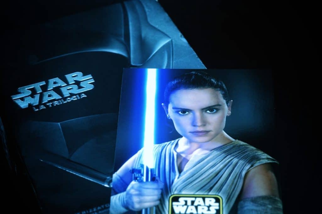 Rey holds a lightsaber in a Star Wars boxset