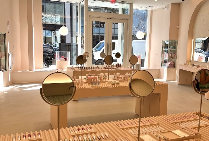 Glossier Chicago showroom shows products displayed on a muted setup