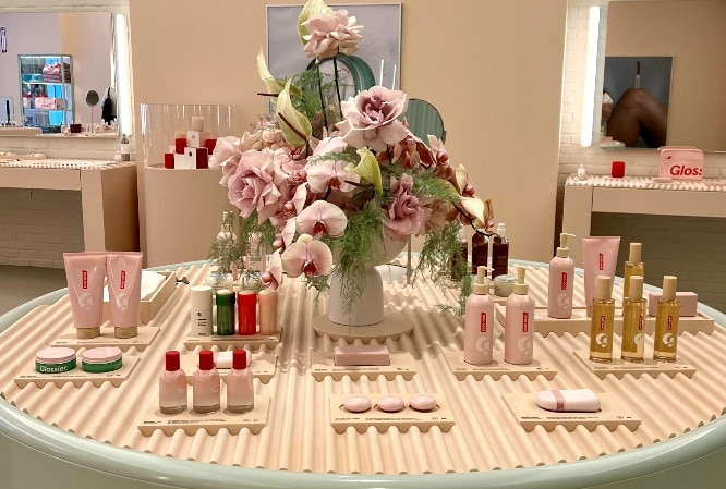Glossier Chicago showroom shows products displayed on a muted setup