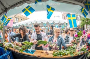 Image of people at a stall at Andersonville Midsommarfest in Chicago surrounded by Swedish flags
