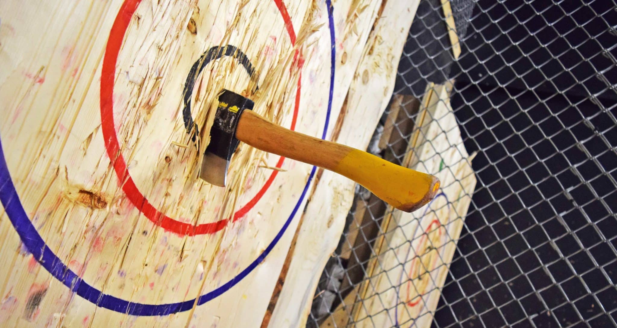 axe thrown in middle of black circle target at an indoor axe throwing hall 