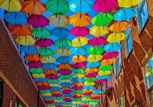 The Umbrella Sky Project pictured in Elmhurst, IL, filling the sky with colorful umbrellas.