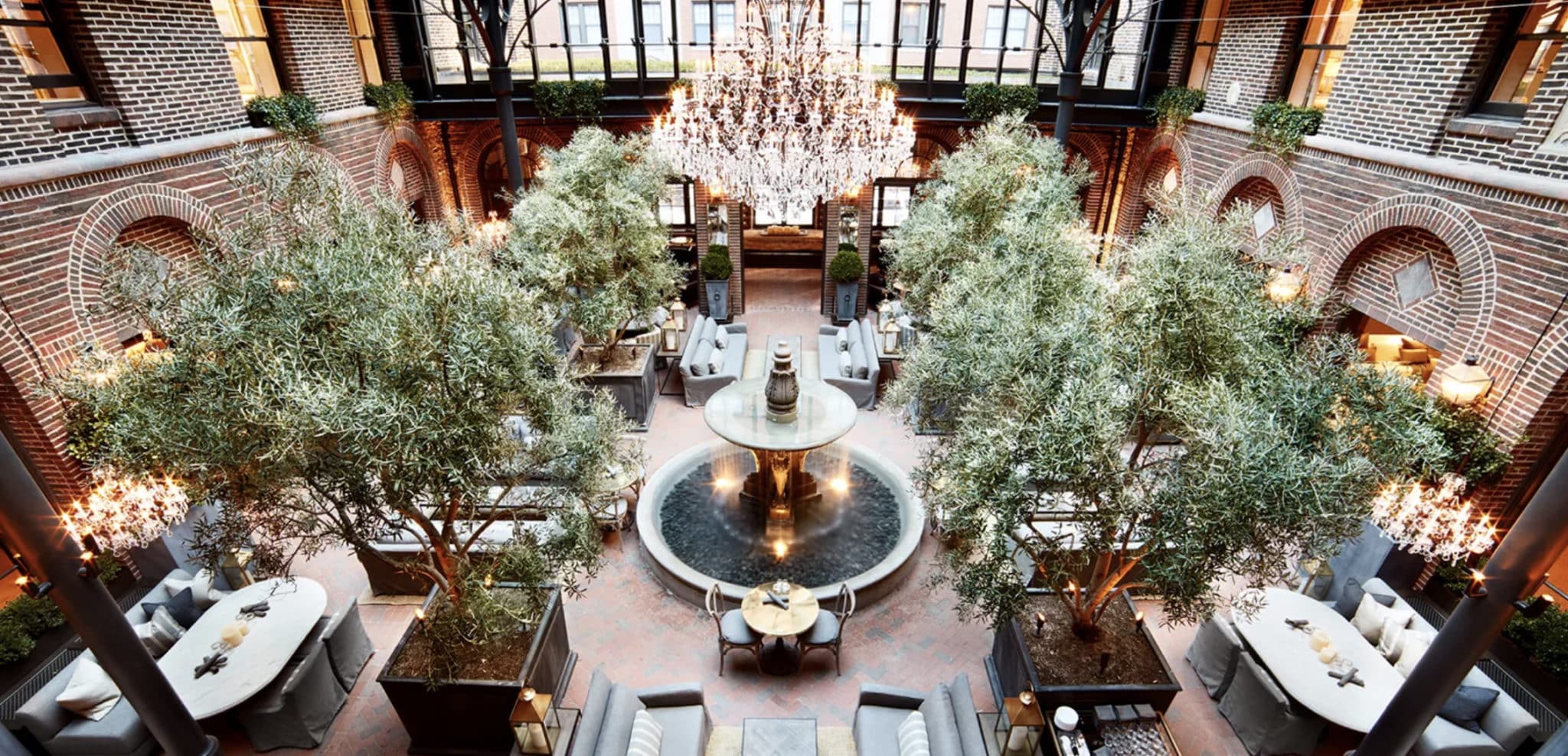 cafe in the restoration hardware in chicago with four large free and a fountain in the middle with a large light fixture and tables for eating