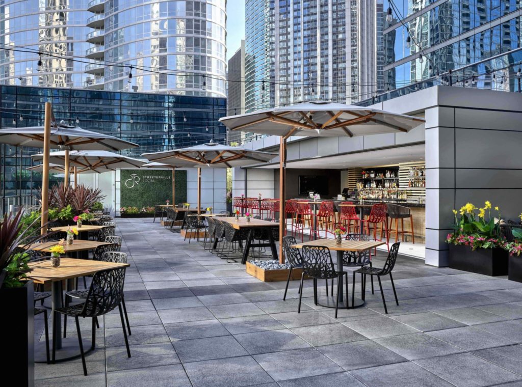 streeterville social bar in Chicago with tables, umbrellas, and a long bar with a neon sign
