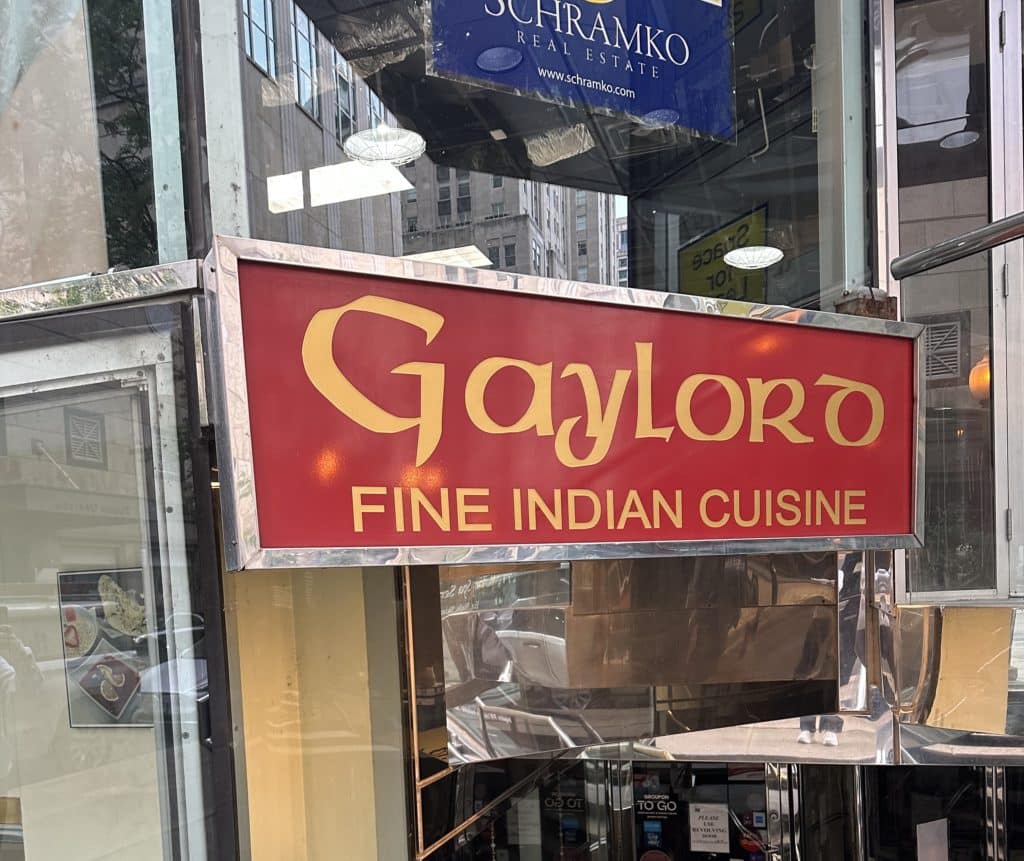 the entrance to gaylord fine Indian cuisine with a red sign on Walton street