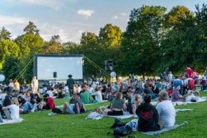 Image show a summer outdoor movie screening in a Park