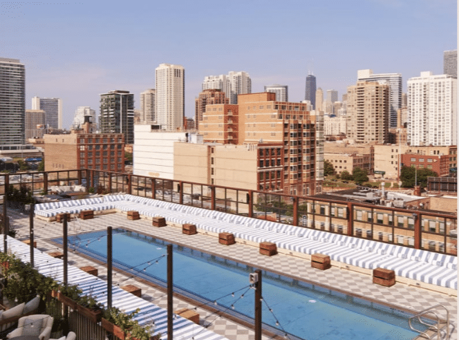 elongated pool with cabanas and lights hanging from above at Soho House Chicago