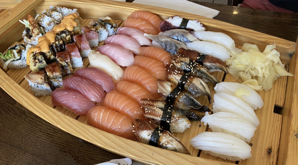 a sushi platter with salmon sashimi, tuna sashimi, white tuna sashimi, sushi rolls in chicago