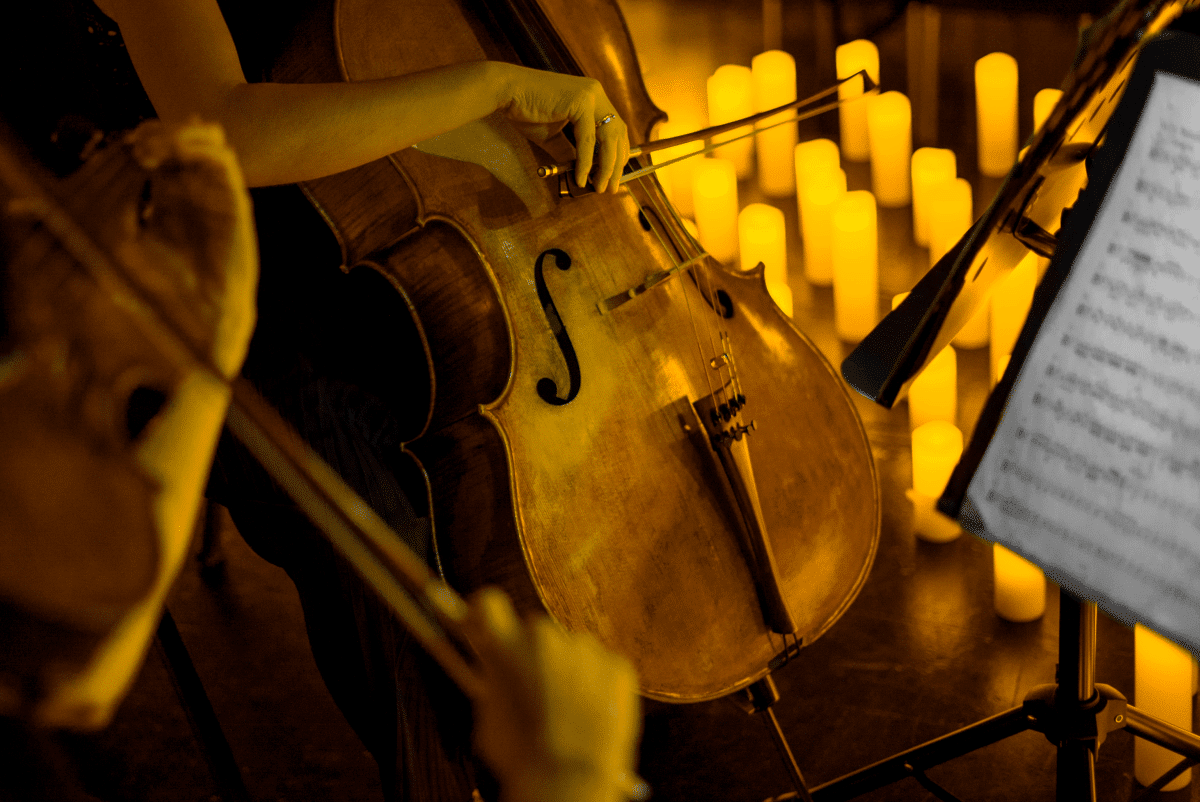 A close up of a cello in the glow of candlelight.
