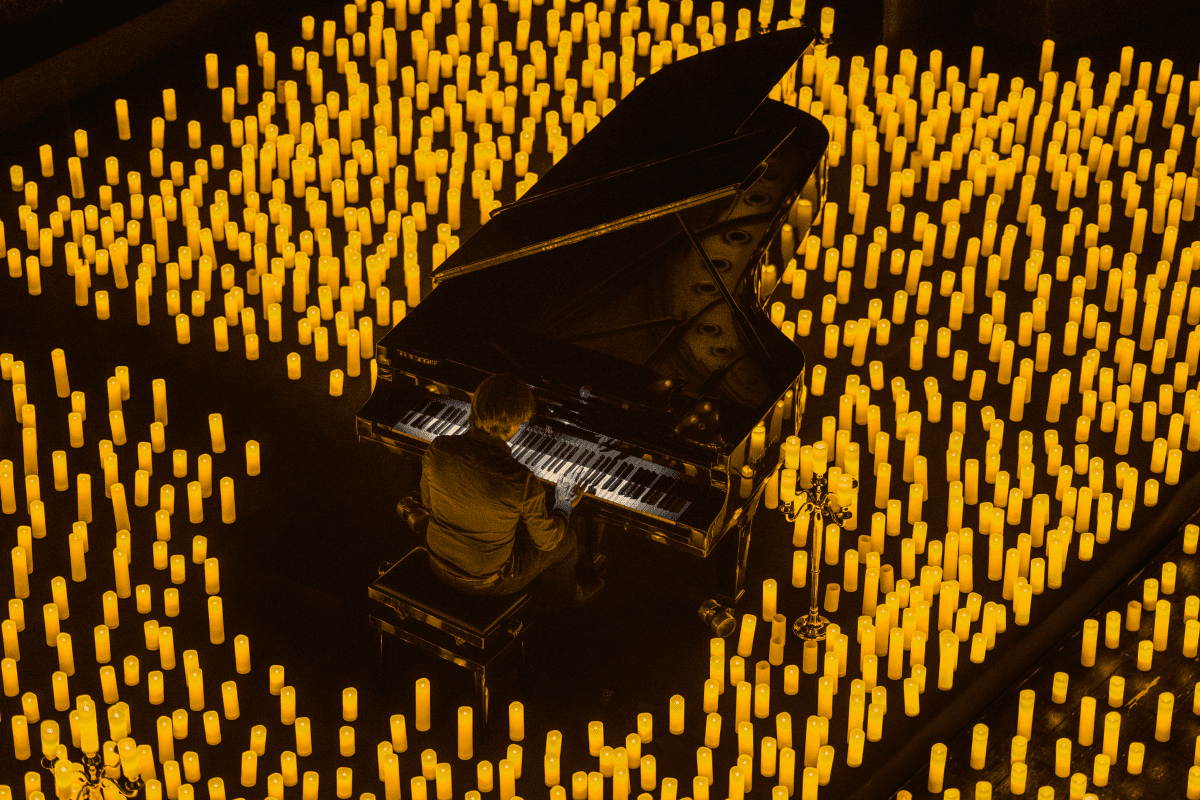 A pianist performing surrounded by candles.