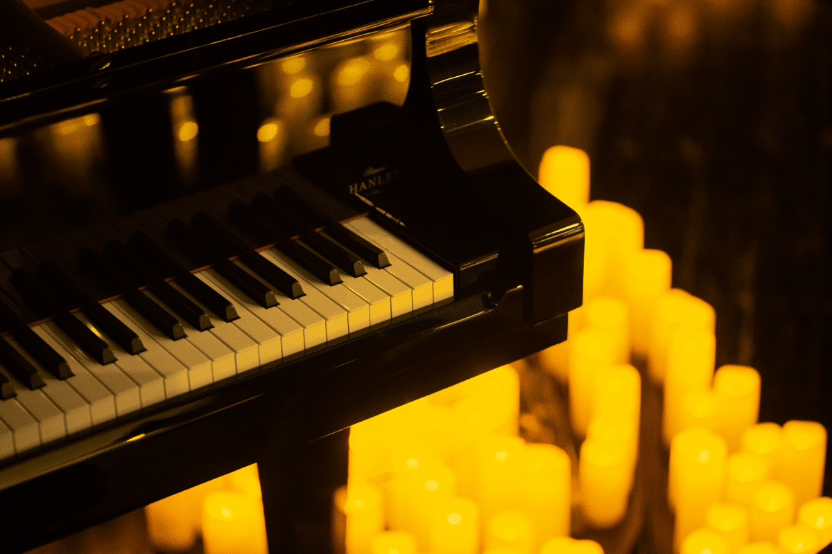 A close up of a piano in the glow of candlelight.