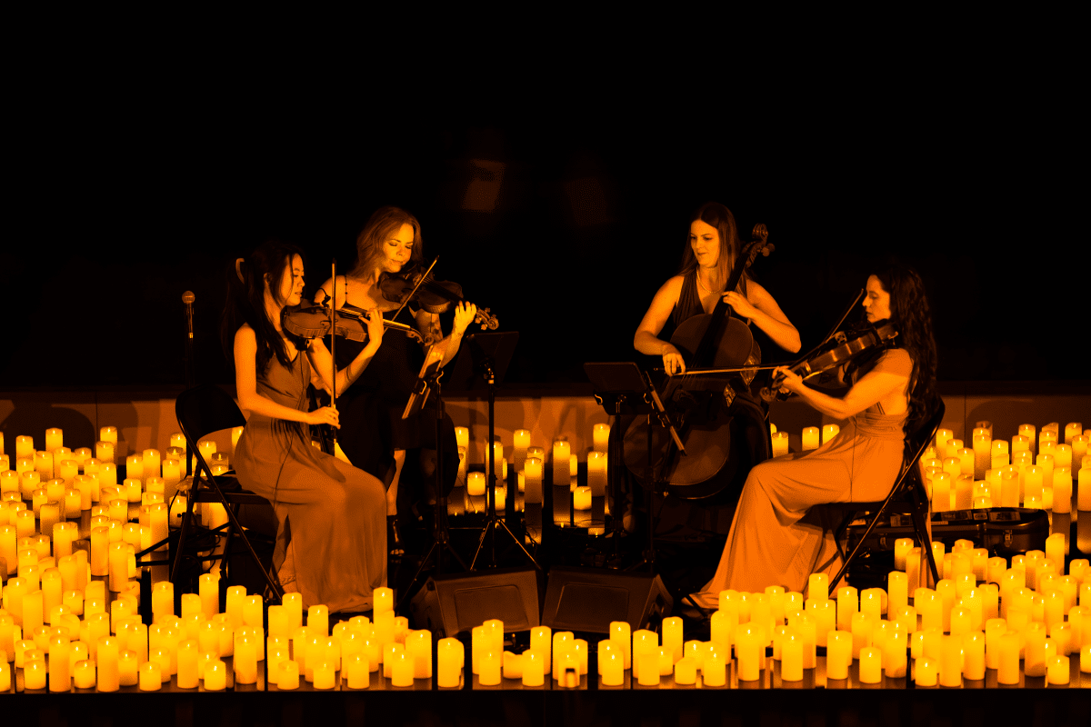 A string quartet performing surrounded by candlelight.