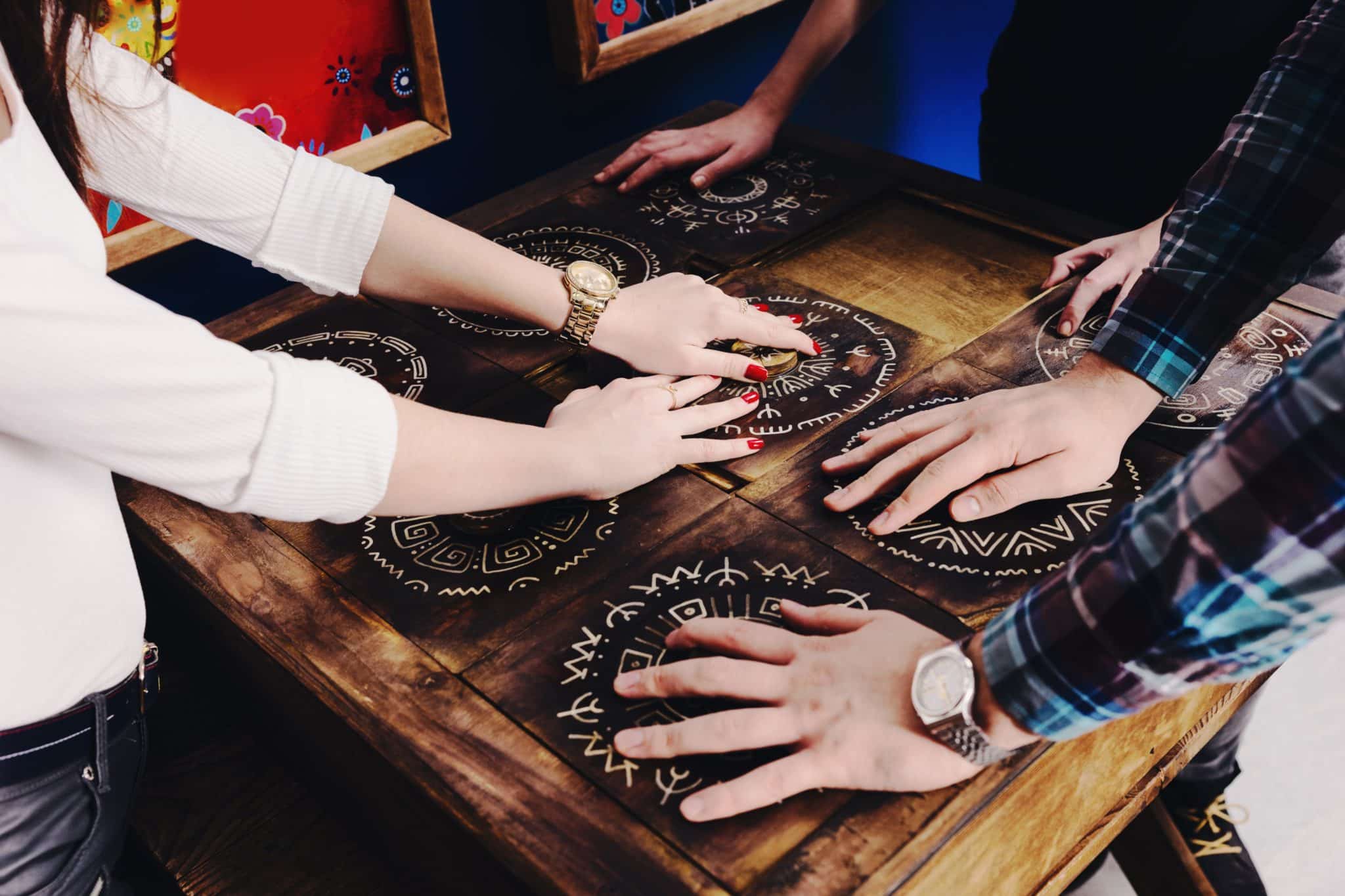 The hands of young people move pieces of the Mexican style trying to get out of the trap, escape the room game concept