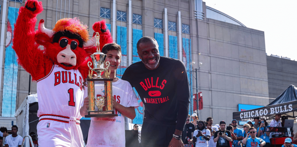 Image showing a boy holding a trophy next to a Chicago Bulls player and the club mascot after winning a competition at Bulls Fest in Chicago