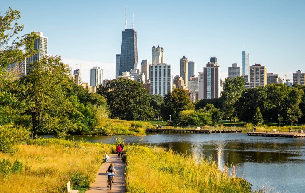 Image showing people enjoying a weekend walking and cycling through a park in Chicago with the Chicago skyline visible in the background