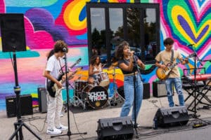 Image showing a band performing live music at a Titan Walls Mural Festival at District Brew Yards in Chicago