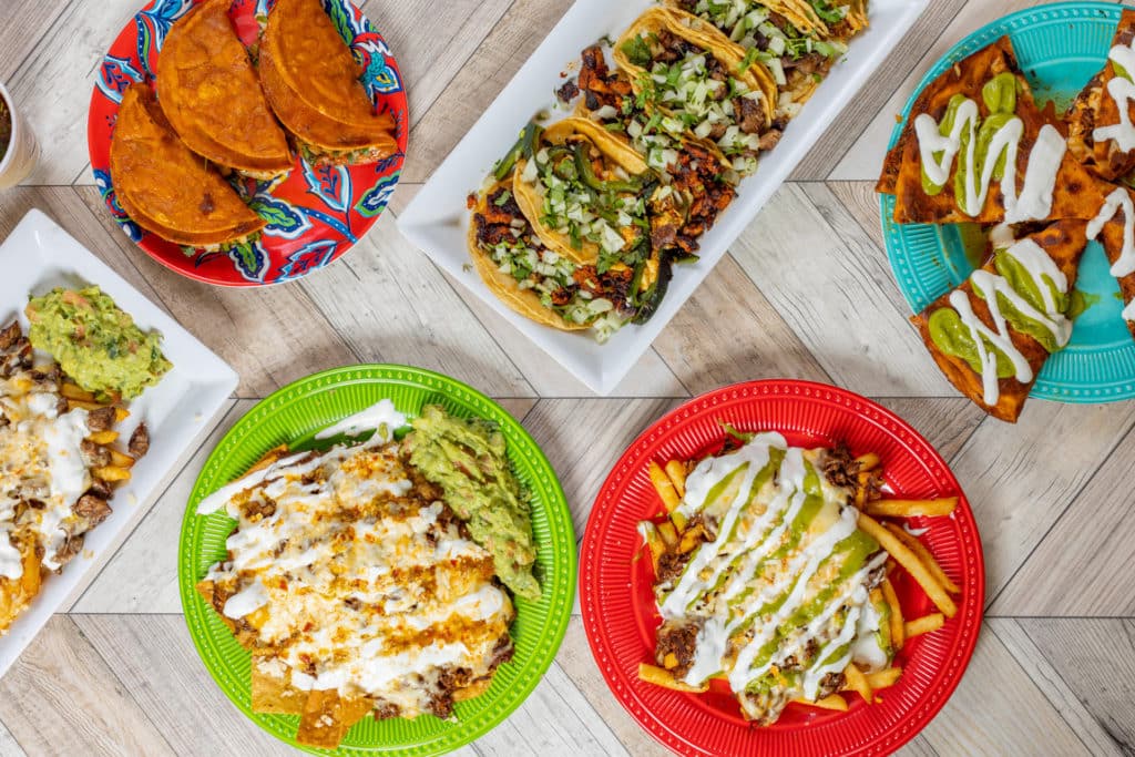 tacos, birrias, and nachos on colorful green, blue, red, and white plates from Tacolatan