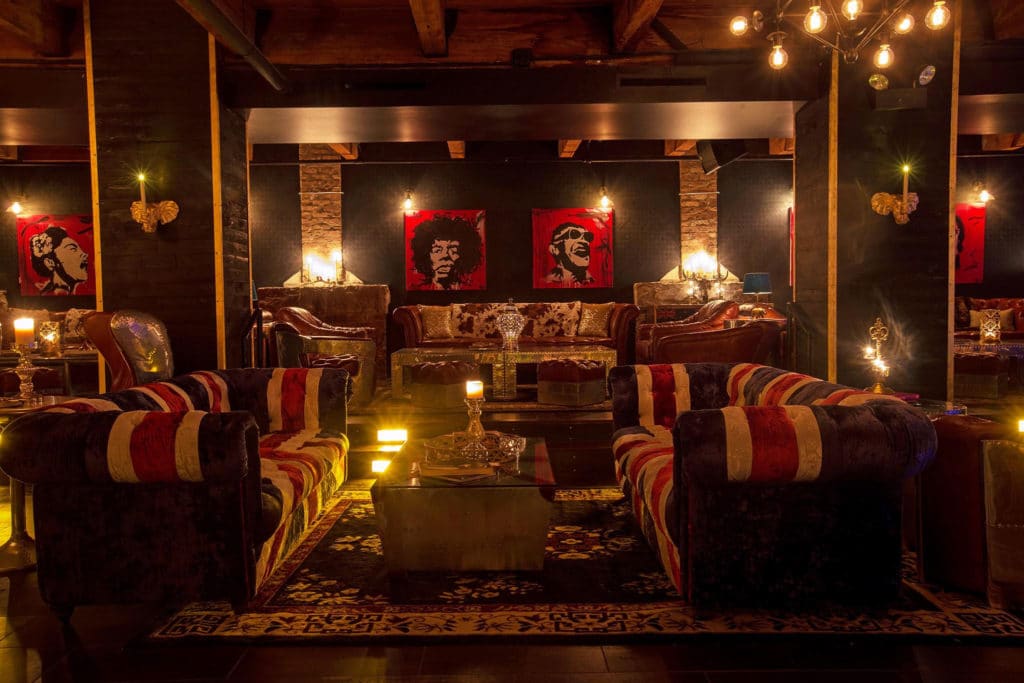 interior of the bassment with velvet couches and lights dangling from the ceiling with a British theme at the Bassment in Chicago