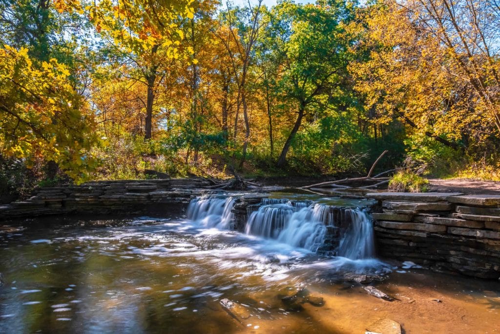 waterfalls with yellow and green foliage at Waterfall Glen Forest Preserve view in Illinois